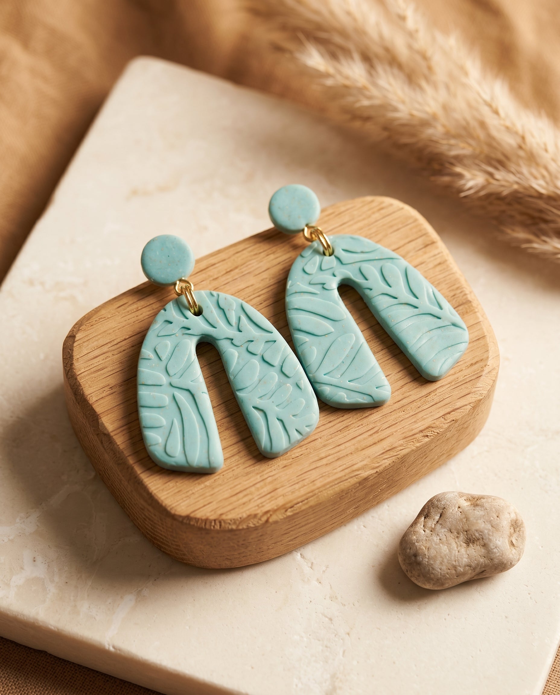 Pendientes Kaiora azules turquesa de arcilla polimérica con textura floral en forma de arco