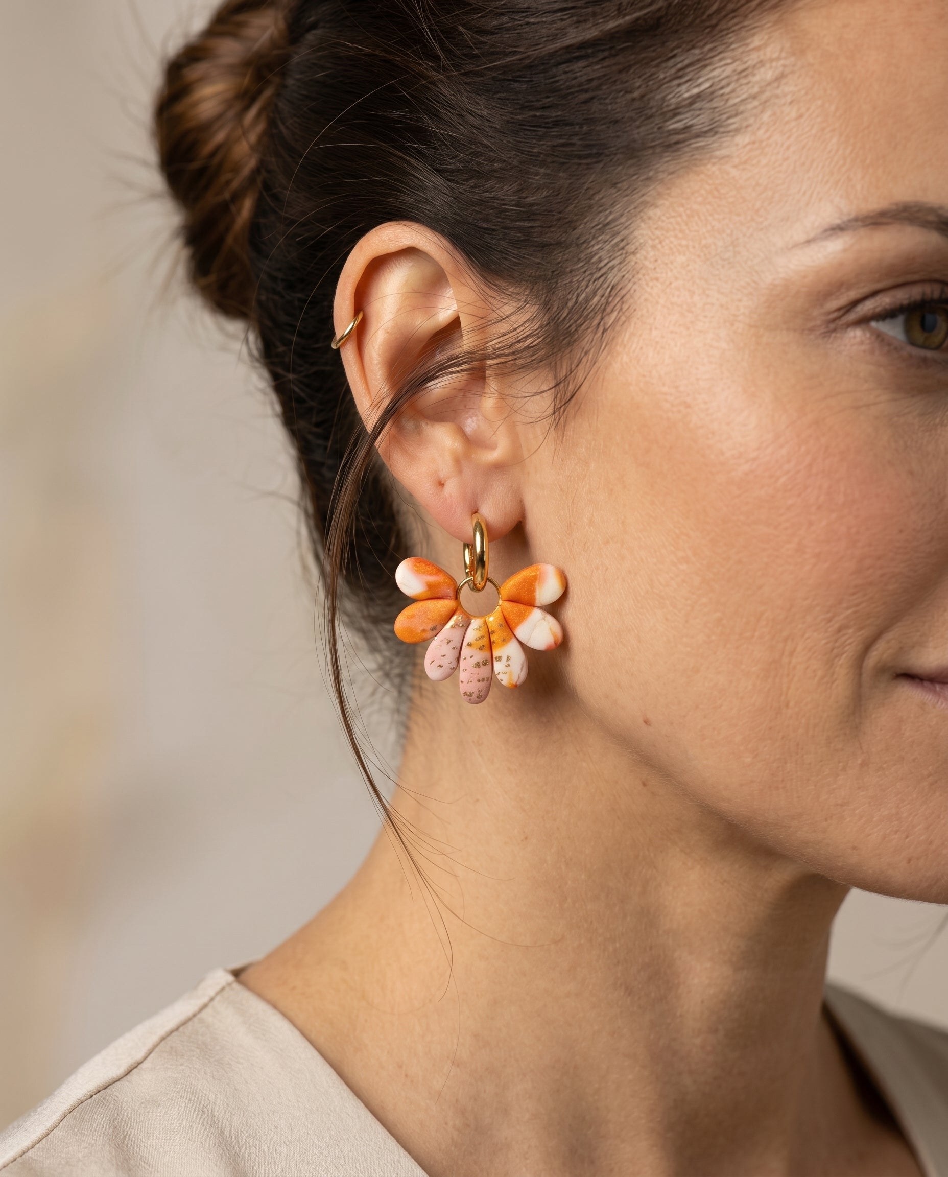 Pendientes colgantes Muse Kaiora marmoleados naranja, crema y rosa con aro y destellos dorados.