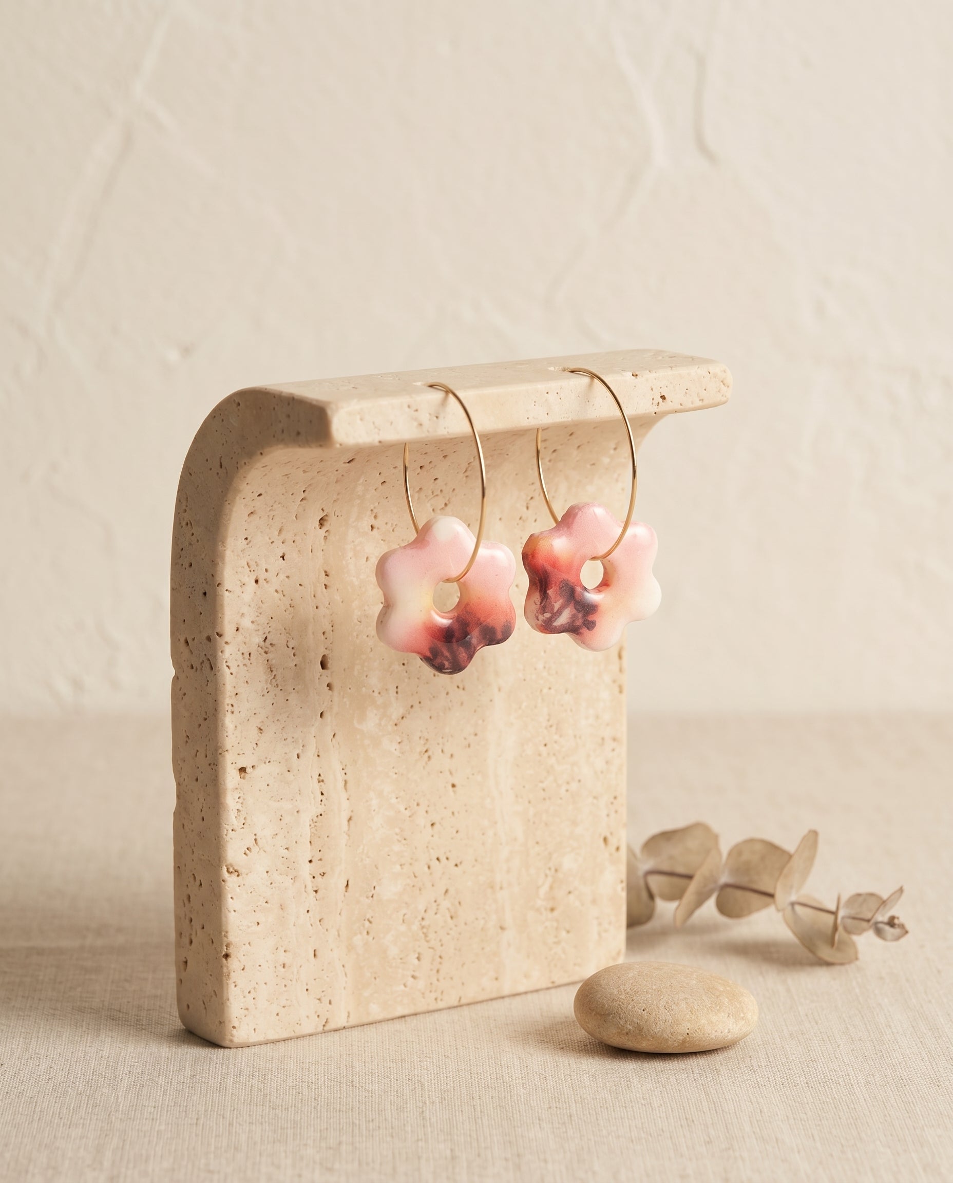 Pendientes Kaiora Estrella Floral con aros dorados y diseño floral en rosa, blanco y burdeos.
