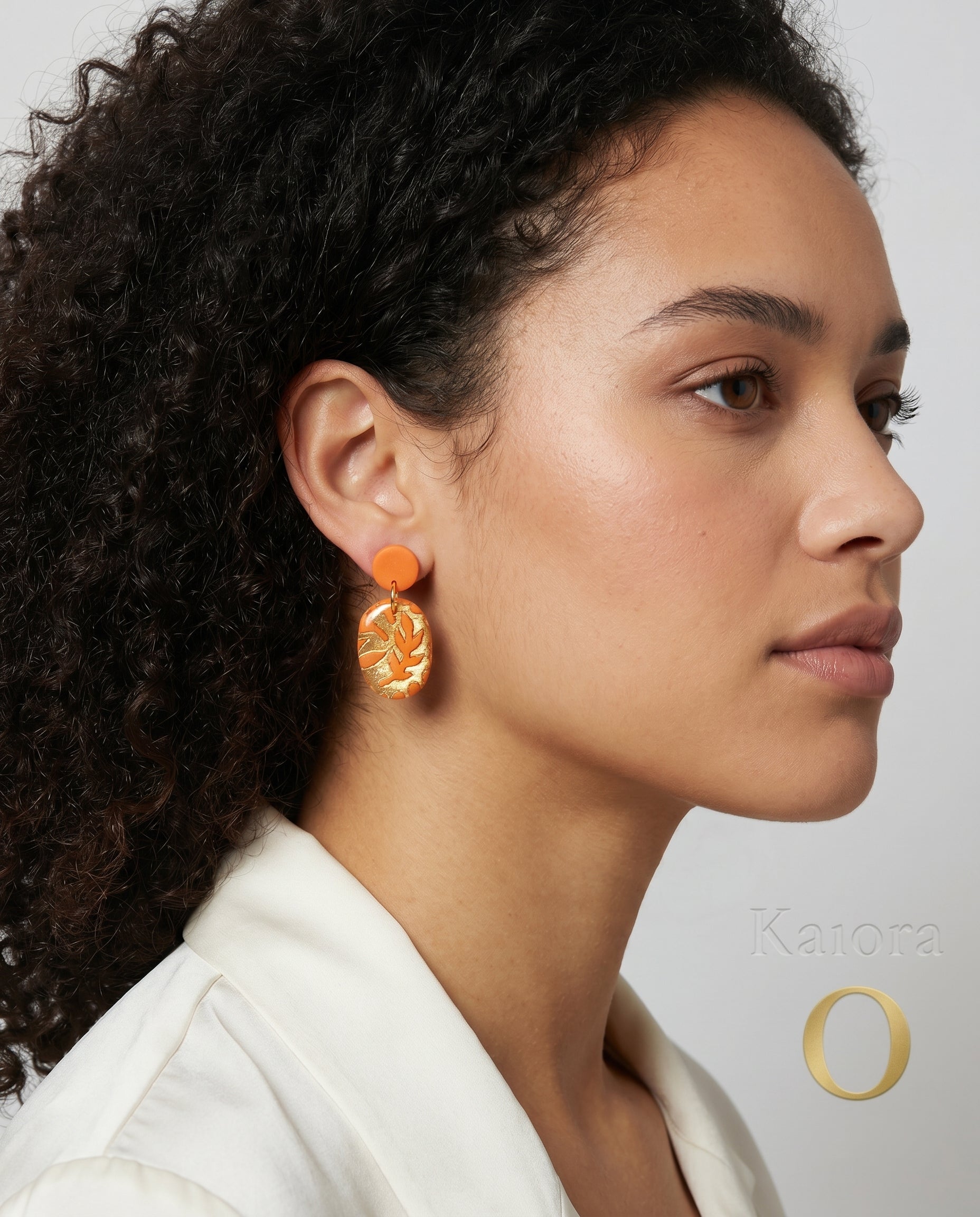 Pendientes Coral Ámbar Kaiora naranjas con diseño de hojas doradas pulidas