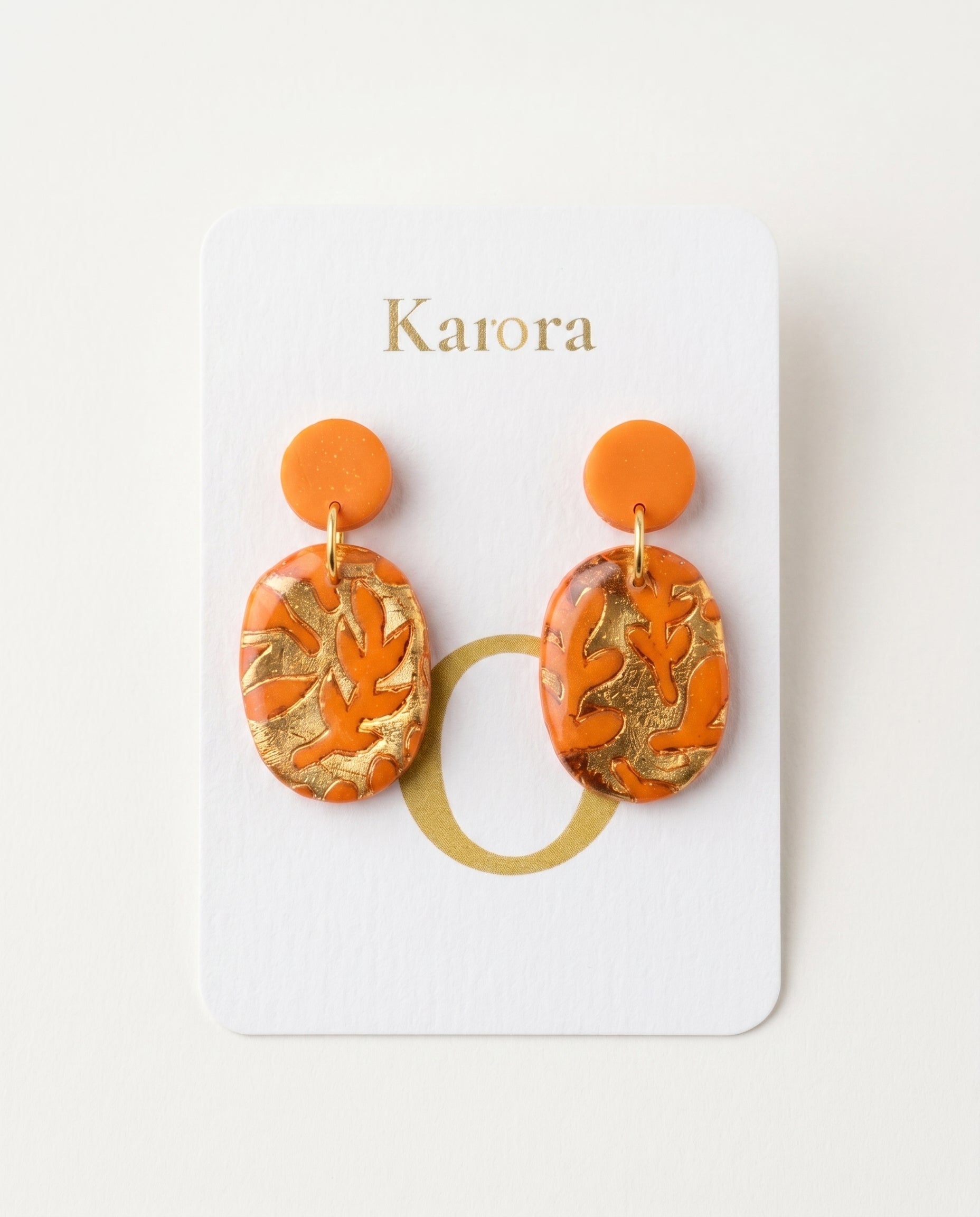 Pendientes Kaiora Coral Ámbar naranjas y dorados con patrón de hojas, diseño artesanal