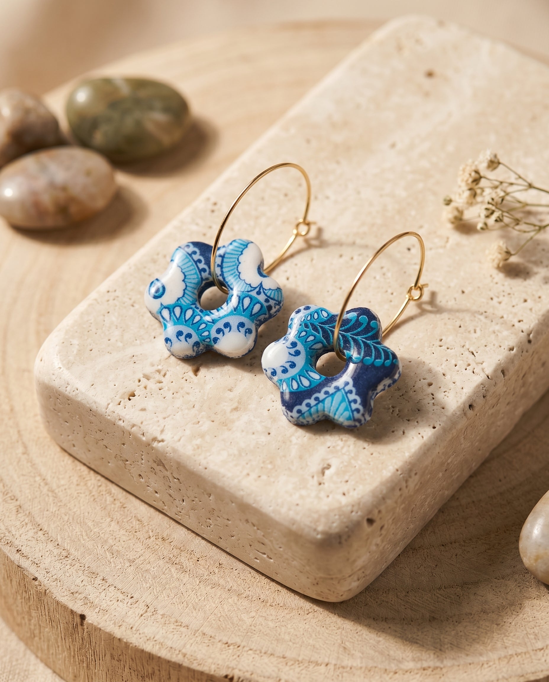 Pendientes Estrella Floral Kaiora azules y blancos con estampado floral y aros dorados.