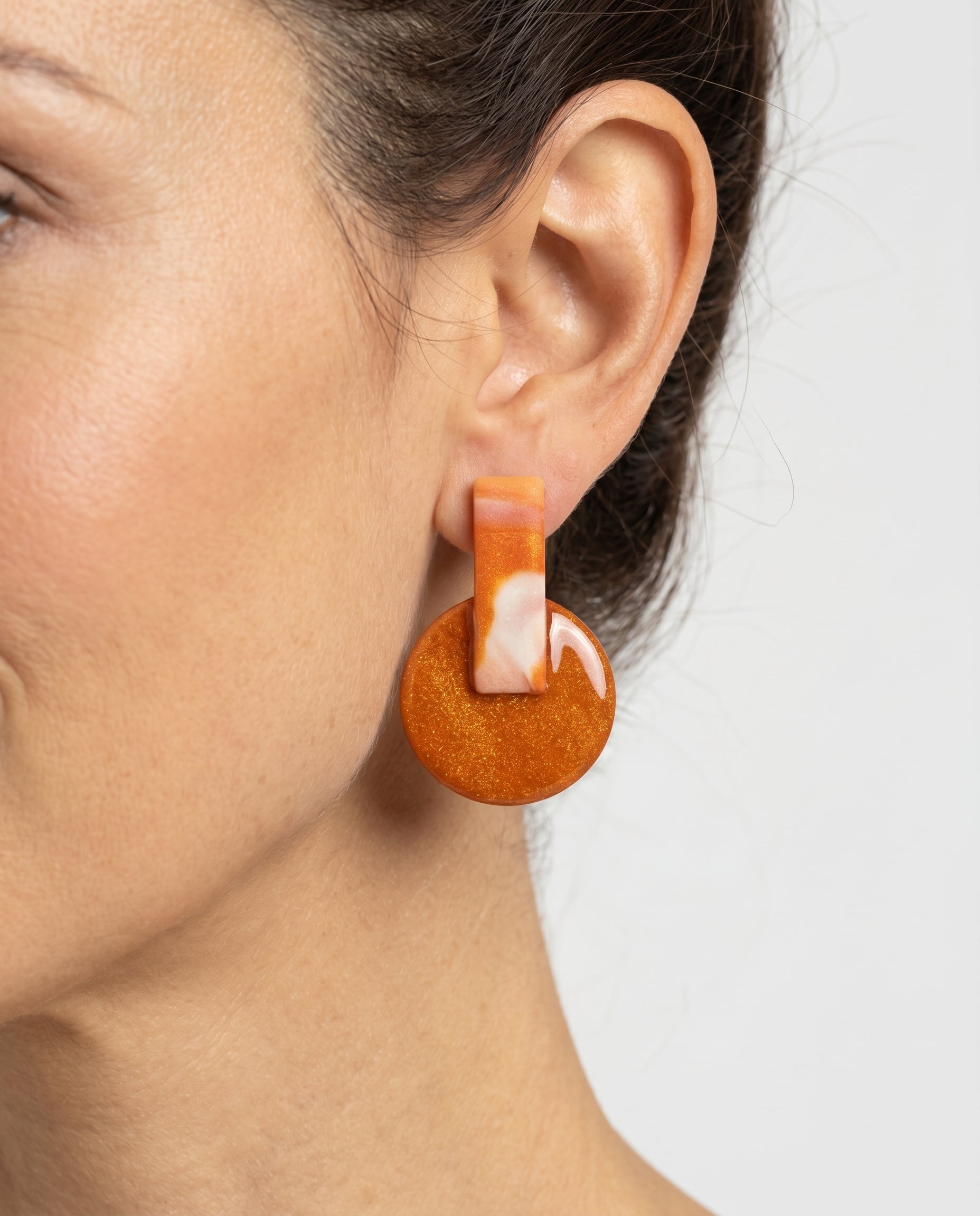 Pendientes Kaiora Coral Salvaje con efecto marmoleado melocotón y crema, base naranja brillante.