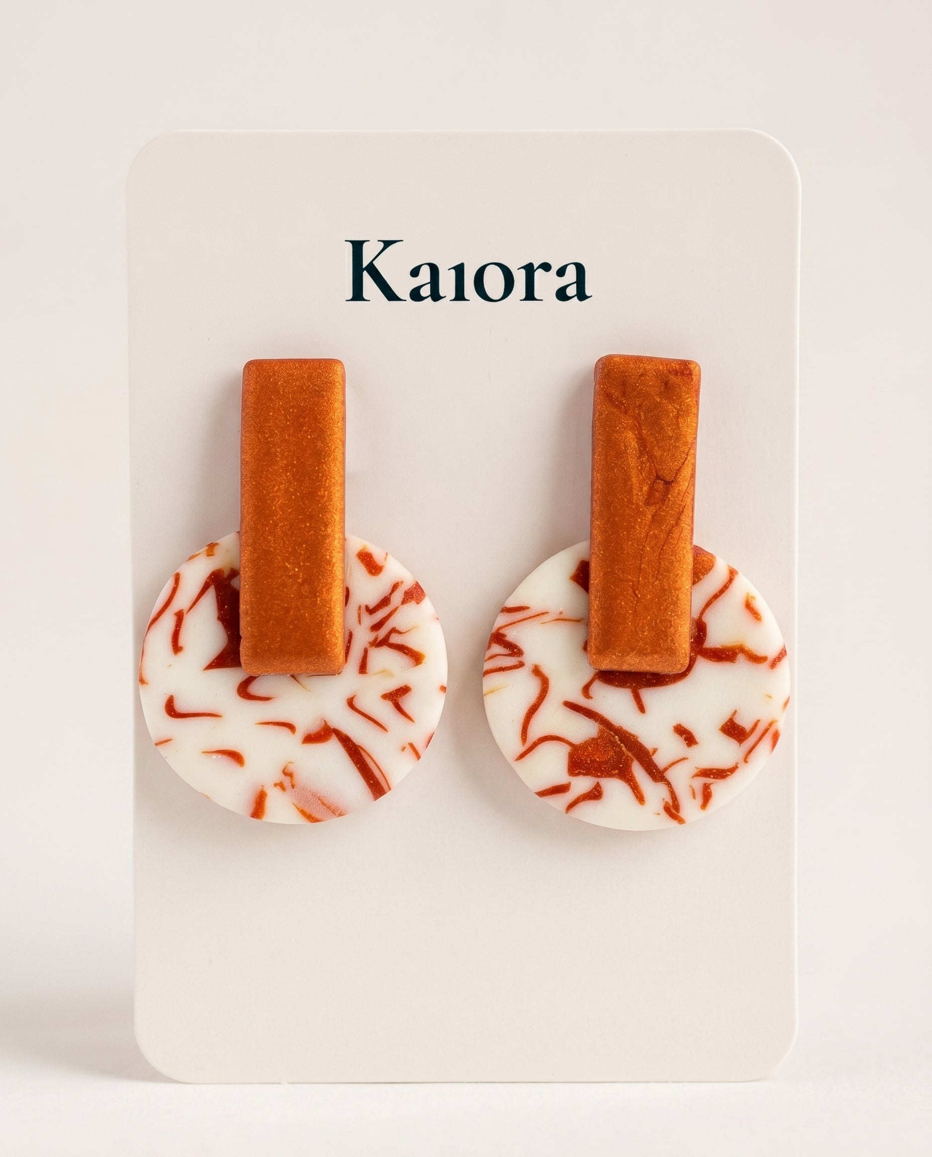 Pendientes Kaiora geométricos con barra naranja y círculo marmoleado en tonos melocotón y crema