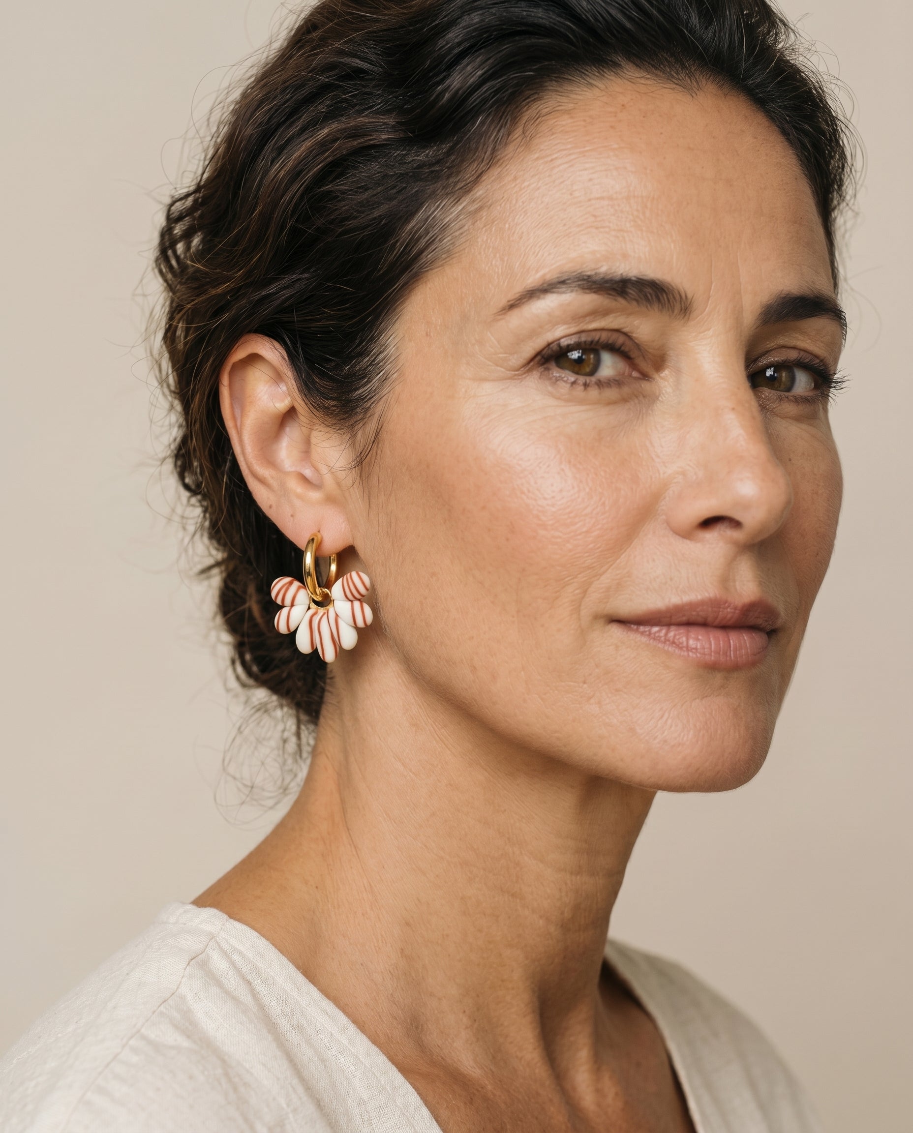 Pendientes Kaiora Dune Bloom dorados con pétalos crema y vetas tierra