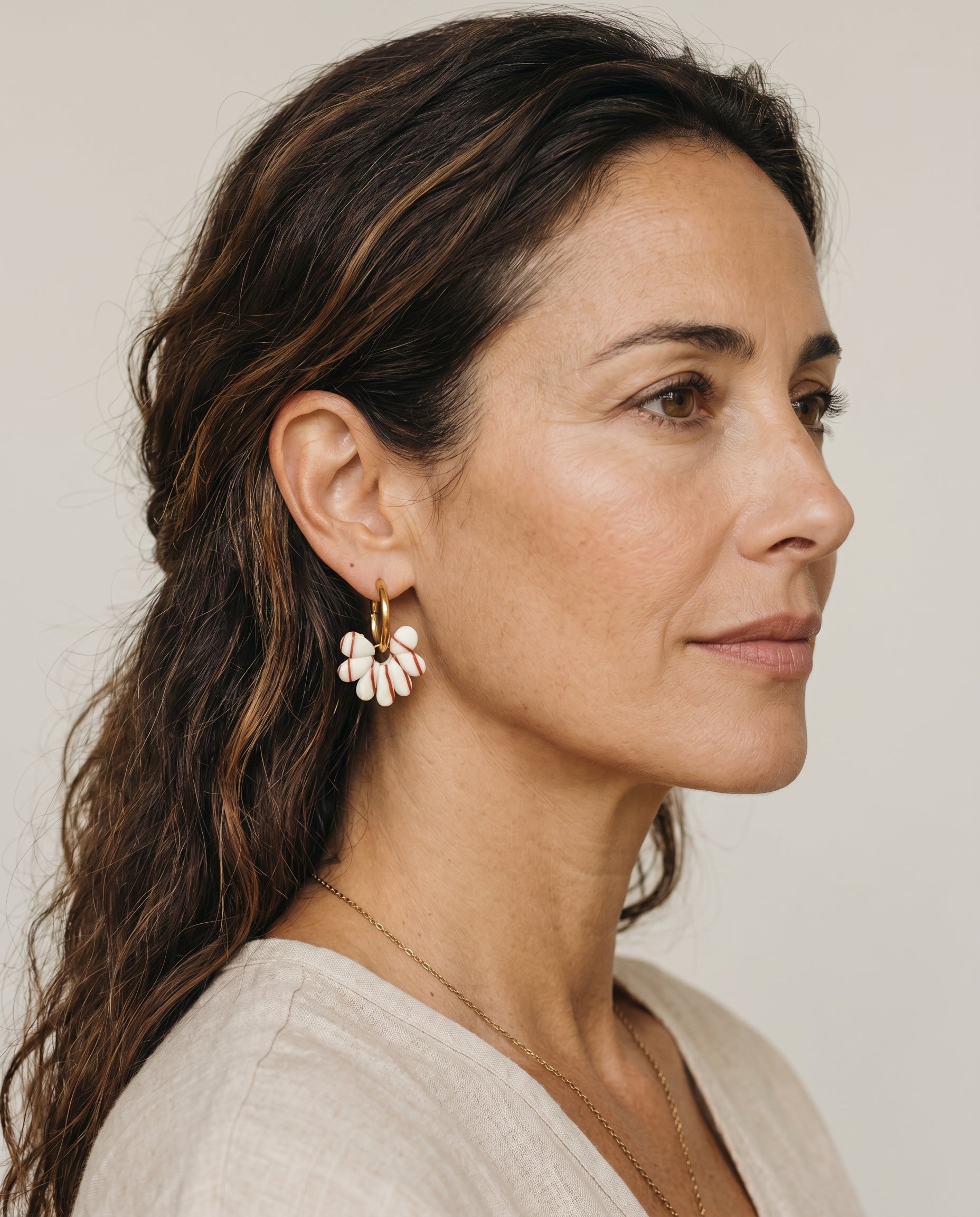 Pendientes Kaiora dorados con diseño floral crema y rayas marrones