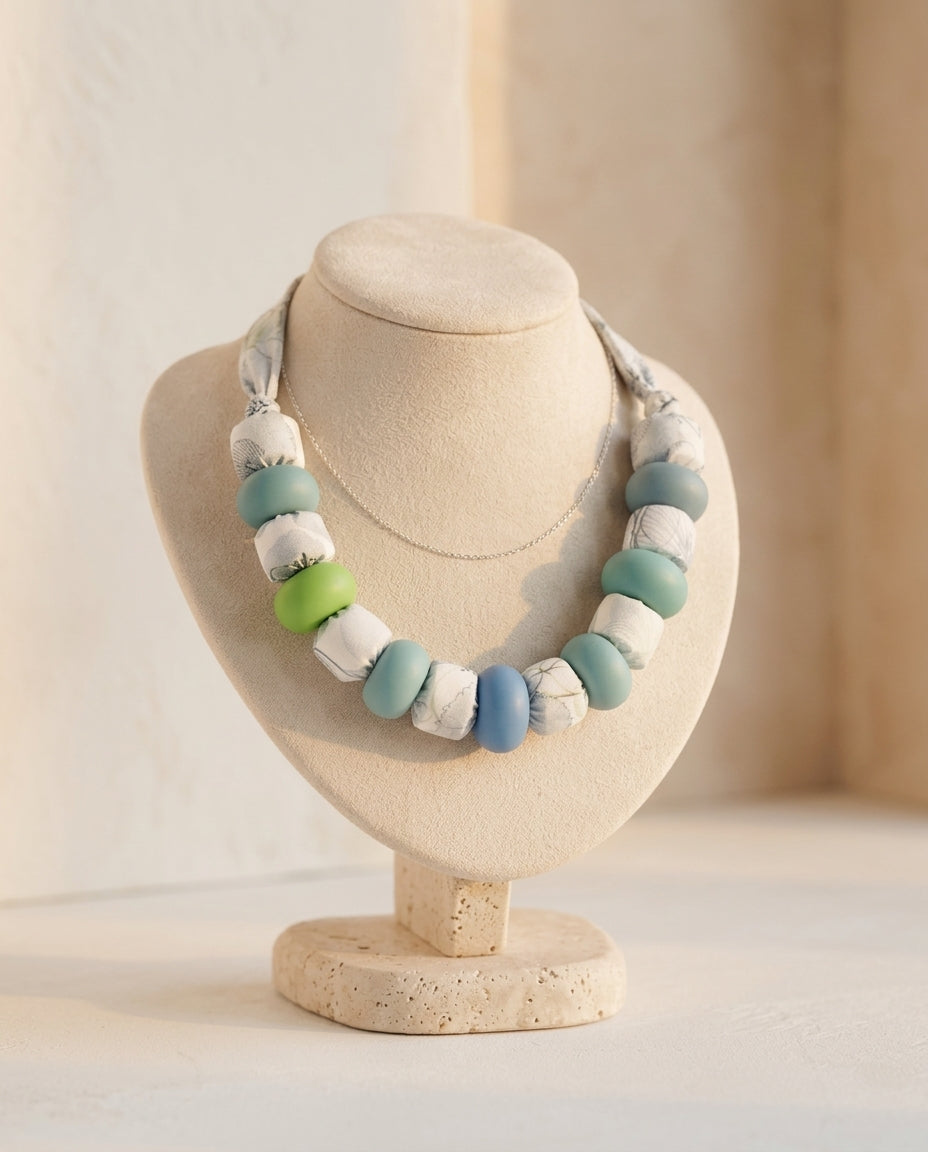Collar Kaiora de cuentas grandes textiles estampadas y lisas verdes, azules y blancas.