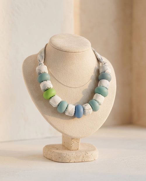 Collar Kaiora de cuentas grandes textiles estampadas y lisas verdes, azules y blancas.